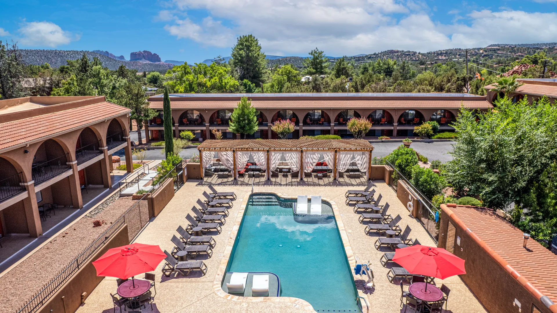 A relaxed Sedona hotel with poolside spaces framed by the surrounding red-rock landscape.